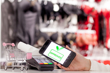 POS terminal, Payment Machine with mobile phone on store background. Contactless payment with NFC technology