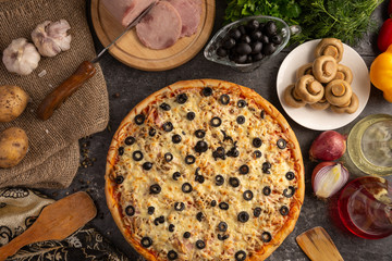 Pizza with ham, mushrooms, black olives and onions