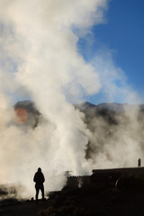 Fototapeta premium Girl against column of smoke in geysers el tatio