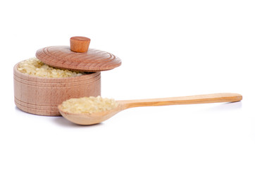 Rice in wooden bowl with lid and spoon on white background isolation
