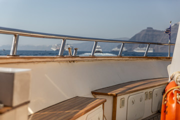 Bridge of a luxury yacht with a beautiful sea and boats in the background