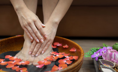 Female feet at spa pedicure procedure.Spa treatment and product for female feet and hand spa,...
