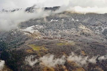 Mountain View with clouds and village in a forest 
