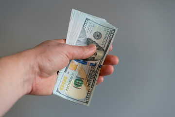 Hand with dollars on a gray background. dollars money finance currency in hand on gray background