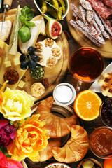 breakfast on table with bread buns, croissants, coffe and eggs
