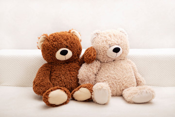 Children's toys - bears of brown and beige color are sitting on the sofa.