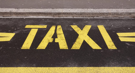 Fototapeta premium Taxi place road sign station yellow symbol letters on city street