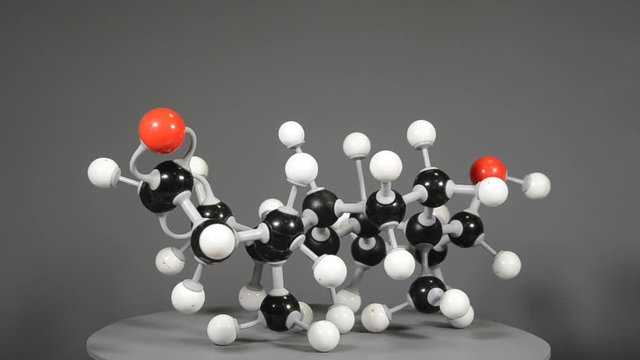 Slowly rotating molecule "stick" model of testosterone. White = Hydrogen, Black = Carbon , Red = Oxygen. Seamless playoff possible.