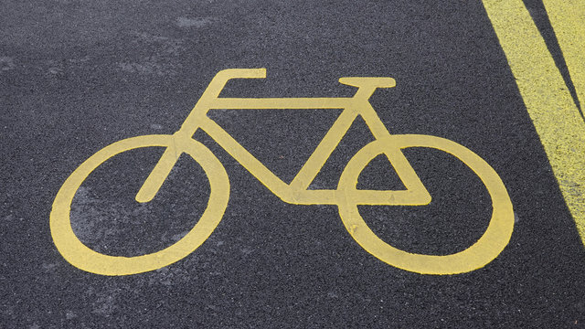 Bicycle place road sign bike trail yellow symbol letters on city street