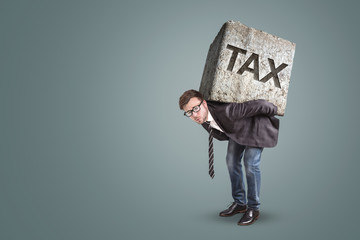 Businessman carrying a heavy stone with the word TAX on it - obrazy, fototapety, plakaty