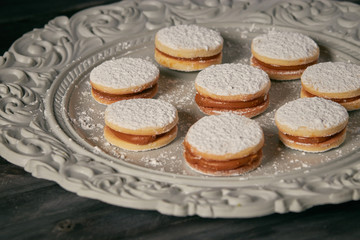 cookie caramel alfajores closeup in ornamented plate over a table