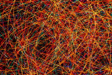 Colorful light painting abstract long exposure image with red, green, blue and yellow lines on a black background