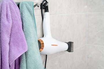 White hair dryer in the bathroom. Hair care