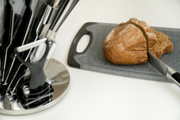Sliced bread and knife. Set of six kitchen knives on a modern kitchen