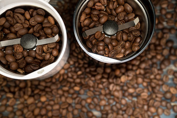 Two coffee grinders with coffee beans isolated on the wooden tables