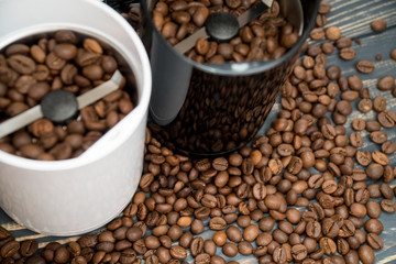Two coffee grinders with coffee beans isolated on the wooden tables