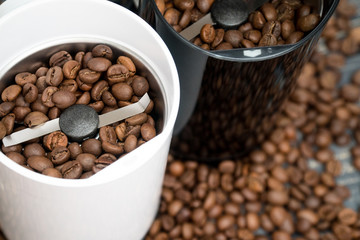 Two coffee grinders with coffee beans isolated on the wooden tables