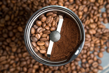 Coffee grinder with coffee beans isolated. In one half of coffee grinder are whole grains of coffee, and in the other half - ground coffee