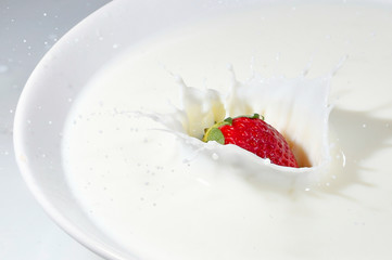 splash of white milk with red strawberries