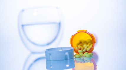 can of pills and a glass of water
