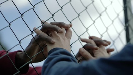 lovers hands touching,holding through net.difficult, forbidden love affairs