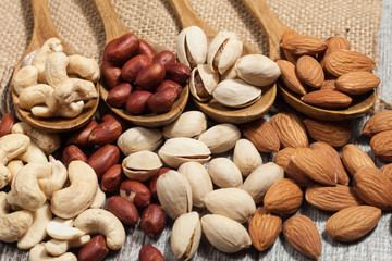 Healthy mix nuts on wooden background. Almonds, hazelnuts, cashews, peanuts, pistachios, brazilian nuts