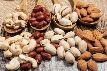 Healthy mix nuts on wooden background. Almonds, hazelnuts, cashews, peanuts, pistachios, brazilian nuts