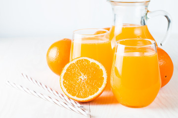 Close-up of a glass of orange juice with oranges fruits on wooden and stone background. Vitamins and minerals. Healthy drink and beverage concept.