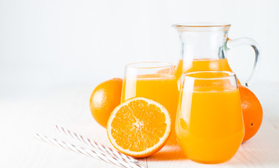 Close-up of a glass of orange juice with oranges fruits on wooden and stone background. Vitamins and minerals. Healthy drink and beverage concept.