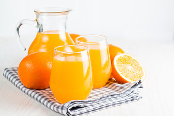 Close-up of a glass of orange juice with oranges fruits on wooden and stone background. Vitamins and minerals. Healthy drink and beverage concept.