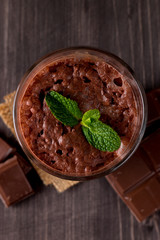 Chocolate, coffee, milk, banana shake on wooden background. Smoothie with mint. Milkshake. Protein diet. Healthy food and drink concept.