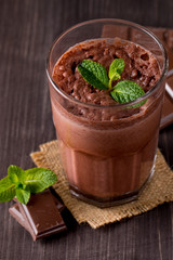 Chocolate, coffee, milk, banana shake on wooden background. Smoothie with mint. Milkshake. Protein diet. Healthy food and drink concept.