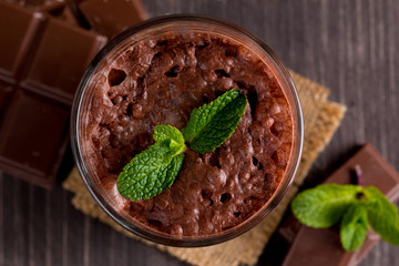Chocolate, coffee, milk, banana shake on wooden background. Smoothie with mint. Milkshake. Protein diet. Healthy food and drink concept.