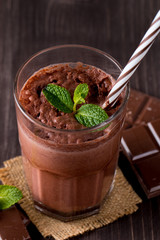 Chocolate, coffee, milk, banana shake on wooden background. Smoothie with mint. Milkshake. Protein diet. Healthy food and drink concept.