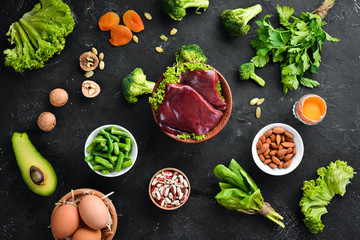 Food containing natural iron. Fe: Liver, avocado, broccoli, spinach, parsley, beans, nuts, on a...