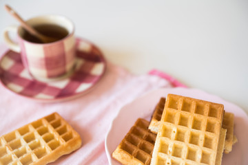Obraz na płótnie Canvas tea time with Belgian waffles, on pink napkin, white table, space for text