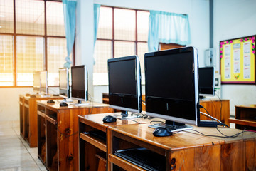 Computers on wooden table in room for education