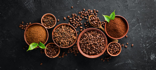Ground coffee and coffee beans. Assortment of coffee varieties on a black background. Top view....