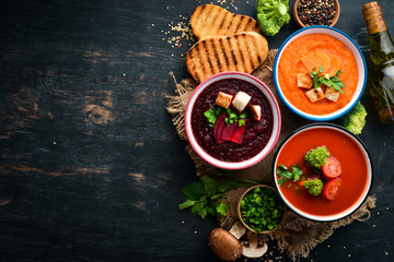 Colored vegetable soup cream. Dietary food. On a black background. Top view. Free copy space.