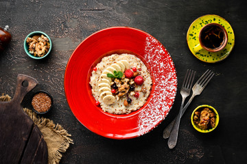 Oatmeal with nuts, banana and wild berries. In the plate. Top view. Flat lay composition Free copy space.