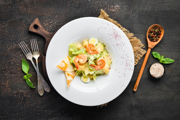 Vegetable Caesar Salad with Shrimp. In the plate. Top view. Free space for your text. Rustic style.
