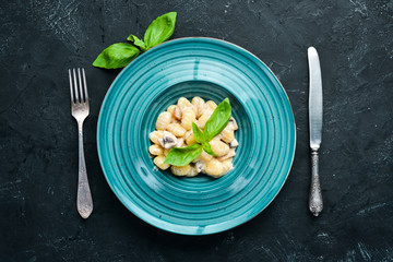 Gnocci In the plate. Italian Traditional Cuisine. Potato dumplings. Top view. Free space for your text. Rustic style.
