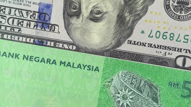 Malaysia ringgit against US dollar bill rotating. Malaysia and USA trade. 4K stock video footage