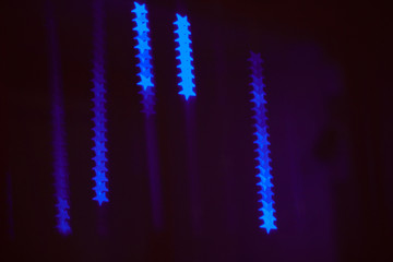 neon light of Christmas garlands in the form of stars on a dark background
