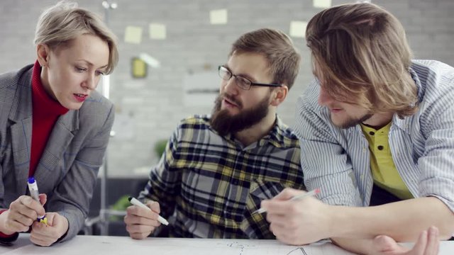 Business team of young consolidated people enjoying working together, millennials group talking having fun in cozy office, good relationships at work. They are happy to work together. They have a