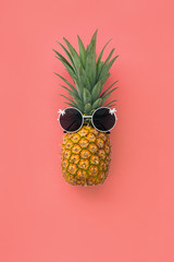 Pineapple fruit in sunglasses on pink pastel background