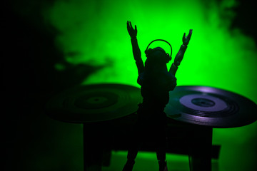 Dj club concept. Woman DJ mixing, and Scratching in a Night Club. Girl silhouette on dj's deck,...
