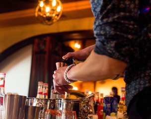 Fototapeta na wymiar barman preparing cocktail in a cocktail bar andr pours liquid into the jigger.
