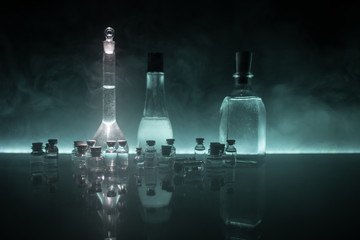 Pharmacy and chemistry theme. Test glass flask with solution in research laboratory. Science and medical background. Laboratory test tubes on dark toned background
