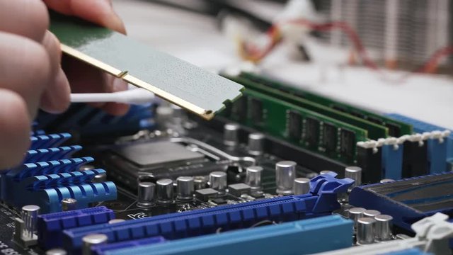 Service for repair and cleaning of computer equipment. The service worker cleans the contacts of the RAM module with a cotton swab. Close-up view, 4K.